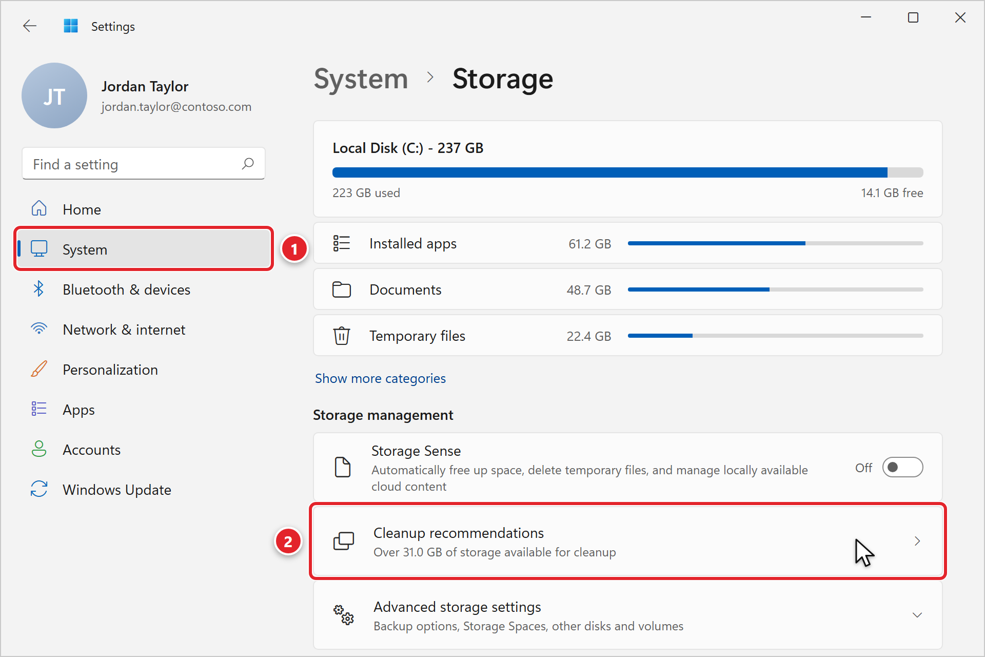 Windows Settings with System selected and marked 1. The Storage page shows Local Disk (C:) - 237 GB with 223 GB used and 14.1 GB free, the largest categories (Installed apps, Documents, Temporary files), and under Storage management: Storage Sense, Cleanup recommendations marked 2 (Over 31.0 GB of storage available for cleanup), and Advanced storage settings.