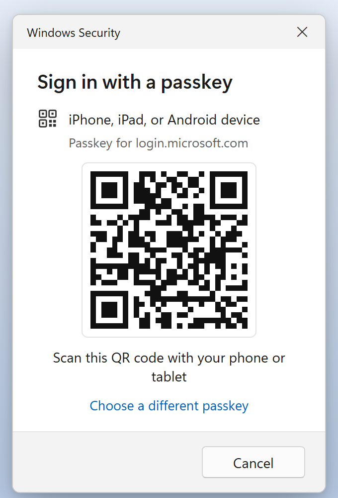 A Windows Security box titled Sign in with a passkey. It shows iPhone, iPad, or Android device, Passkey for login.microsoft.com, a square QR code, and the words Scan this QR code with your phone or tablet. Below are the link Choose a different passkey and a Cancel button. Nothing is marked.